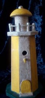WOODEN LIGHTHOUSE DESIGNED WITH YELLOW AND NATURAL WOOD LOOK ON GREEN 
